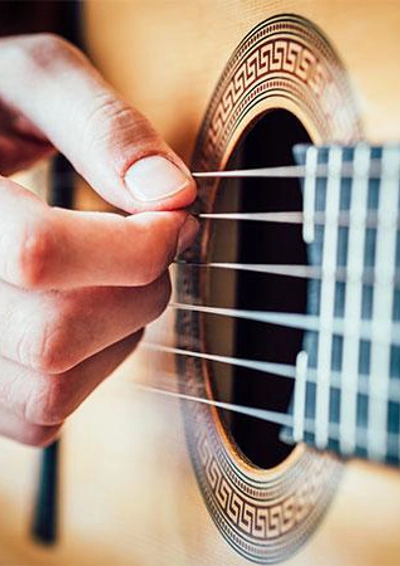 En hånd på en akustisk guitar