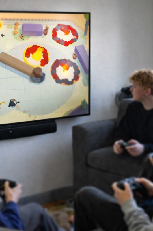 Unge som spiller spil med controllere på tv